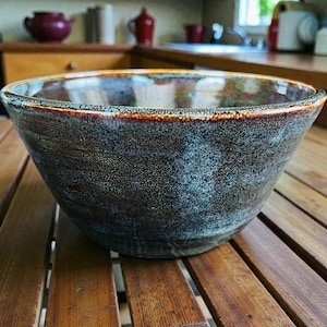 May include: A set of three ceramic mugs with a speckled, matte finish. The mugs are in shades of cream, light gray, and dark gray. Each mug has a simple, minimalist design, perfect for coffee or tea.