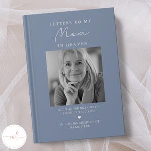Op de afbeelding: Een blauw dagboek met de tekst "Brieven aan mijn moeder in de hemel" en een zwart-witfoto van een vrouw. Onder de foto staat de tekst "Alle dingen die ik je wil vertellen" en een klein hartje. De tekst "Ter nagedachtenis aan Naam hier" staat onderaan het dagboek.