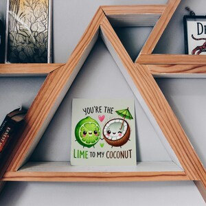 May include: A card with a lime and a coconut with faces on them. The lime is holding the coconut's hand. The text on the card reads "You're the lime to my coconut."