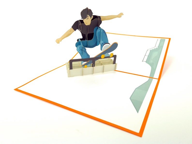 May include: A 3D pop-up card featuring a person skateboarding on a ramp. The card is white with an orange border and a green ramp in the background.