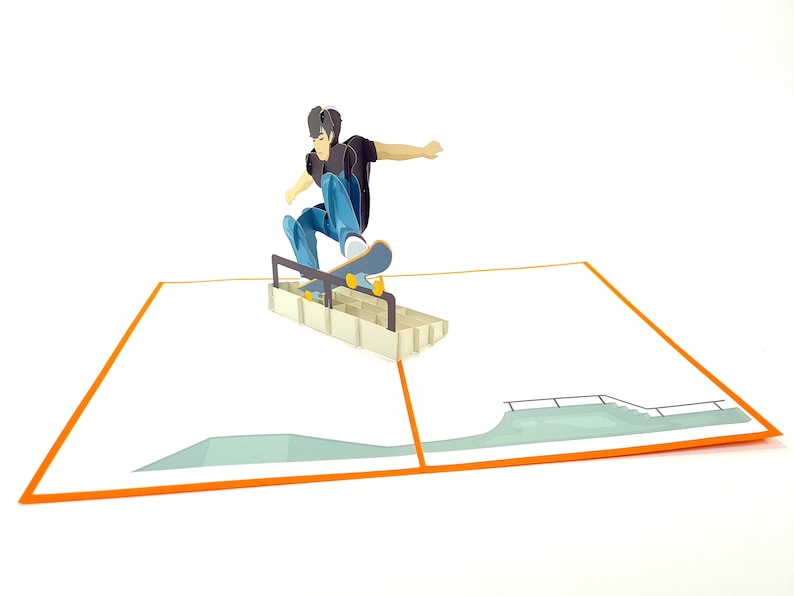 May include: A 3D pop-up card featuring a person skateboarding over a ramp. The card is open and the person is in mid-air, with their skateboard wheels touching the ramp. The card is on a white background.