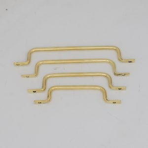 May include: Four gold-coloured cabinet pulls in varying sizes. Each pull has a curved handle with mounting plates on each end. The pulls are arranged in descending order, with the largest at the top and smallest at the bottom.