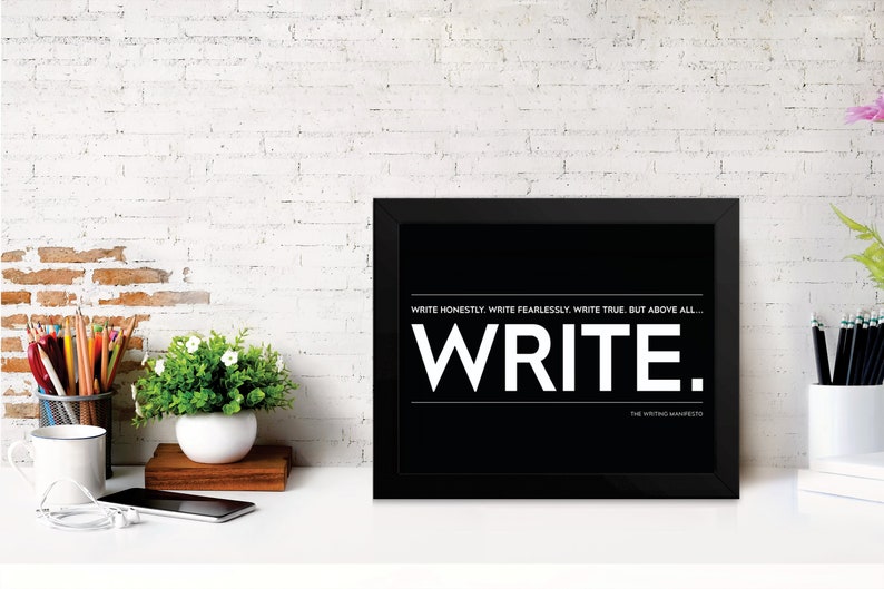 May include: Black and white framed print with the text "Write Honestly. Write Fearlessly. Write True. But above all... WRITE." and the text "The Writing Manifesto" at the bottom.
