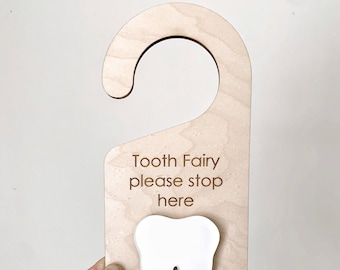 May include: Wooden tooth fairy door hanger with a white tooth cutout and the text "Tooth Fairy please stop here".
