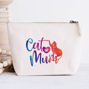 Op de afbeelding: Een witte canvas tas met rits met een kleurrijk aquarelontwerp van een kat en de tekst "Cat Mum".