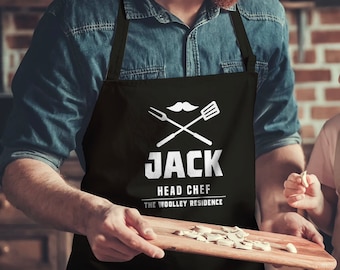 May include: Black apron with a white mustache, crossed fork and spatula, and the text "Jack Head Chef The Woolley Residence".