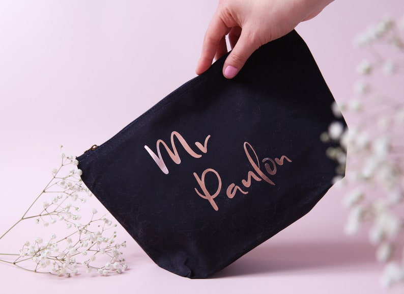 May include: A black canvas zippered pouch with a rose gold inscription that reads "Mr. Panlon".