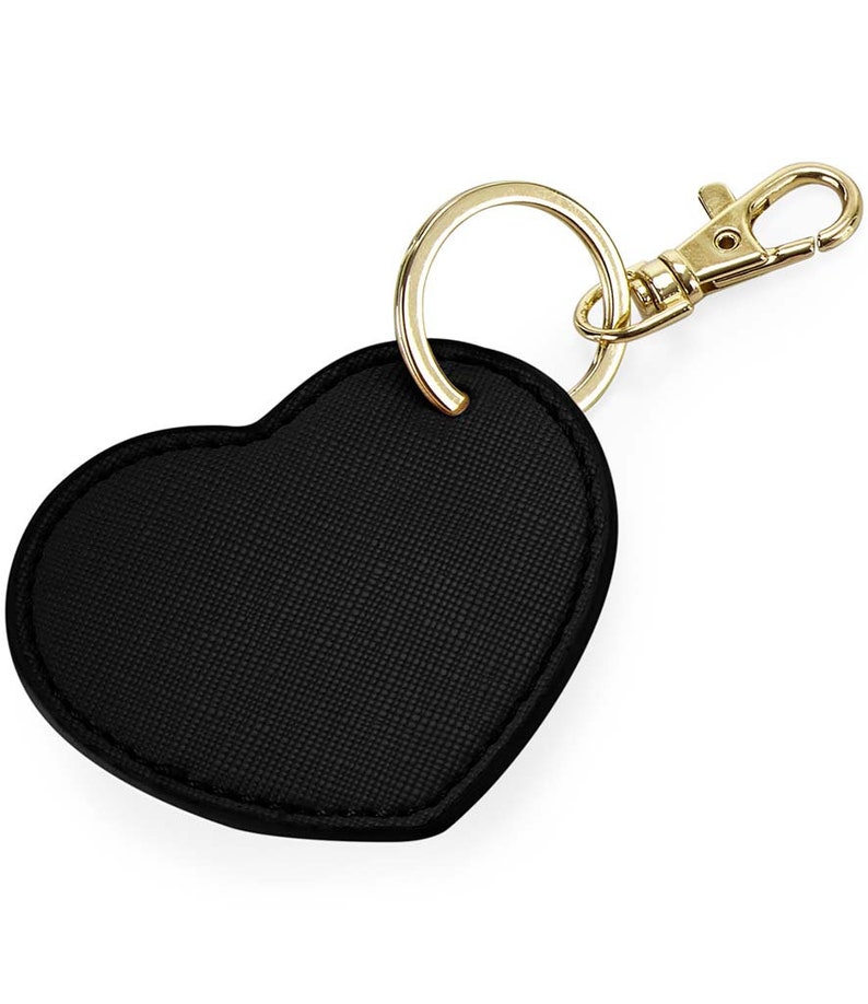 May include: A black heart-shaped leather keychain with a gold metal ring and clasp.