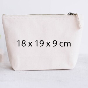May include: A white canvas zippered pouch with the dimensions 18 x 19 x 9 cm printed on the front.