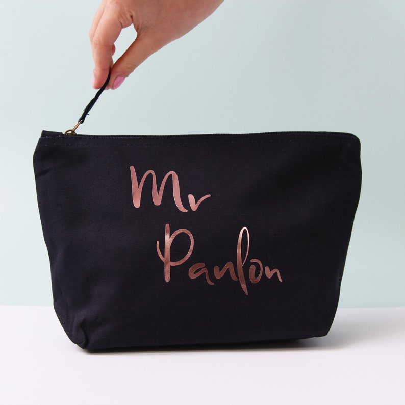 May include: Black canvas zippered pouch with a rose gold inscription that reads "Mr. Panlon".