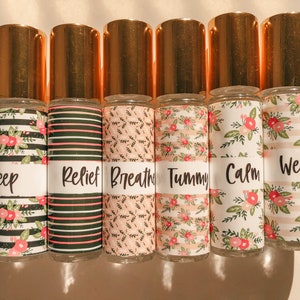 May include: Six gold roller bottles with floral patterned labels. The labels have the words "Sleep", "Relief", "Breathe", "Tummy", "Calm", and "Wellness" printed on them.