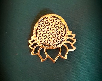 May include: A gold-colored metal pendant featuring a flower design with a geometric pattern in the center. The pendant is a popular symbol of sacred geometry.