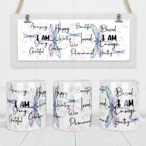 May include: White ceramic mug with a colorful dragonfly design and the text "Amazing Happy Beautiful Blessed I AM Strong Creative Grateful Wise Phenomenal Loved I AM Enough Healthy" printed on it.
