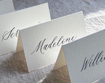 Moderne Kalligraphie Platzkarten beschriftet mit schwarzer Tinte, handgeschriebene Platzkarten, Namenskärtchen für Hochzeiten, Partys und besondere Anlässe