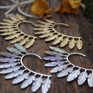 May include: Four ear cuffs with a feather design. Two are gold and two are silver.