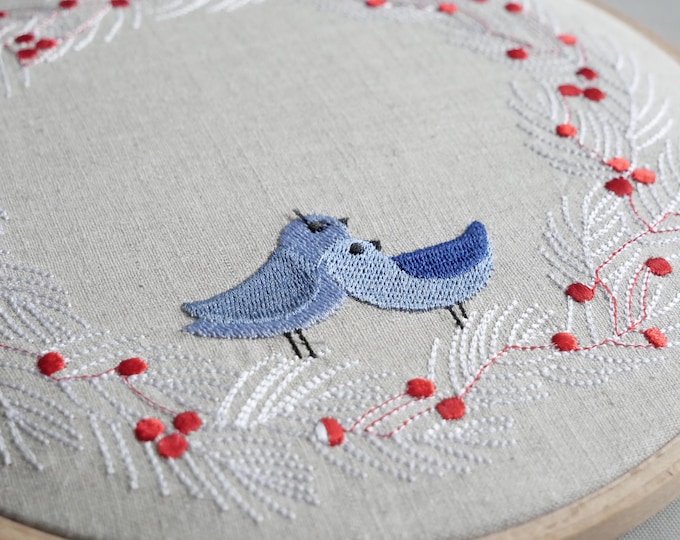 Embroidered picture Blue Birds on white branch with red berries in a round frame for wall decoration