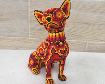 ウイチョル族のチワワの座っている犬の像、メキシコのビーズ細工の民芸品。