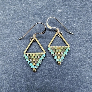 May include: A pair of gold triangle earrings with turquoise and green beaded fringe.
