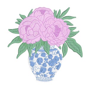 May include: Embroidered design of pink peonies in a blue and white vase. The vase has a floral pattern. Green leaves surround the flowers. The design is on a white background.