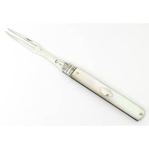 May include: A silver and mother-of-pearl serving fork with a decorative handle. The handle has a small, round, silver inlay.