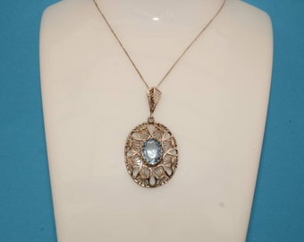 May include: A silver necklace with a delicate filigree pendant featuring a light blue gemstone.