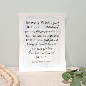 May include: A watercolor print with a blue and white background featuring a bible verse from Lamentations 3:22-24. The verse reads "Because of the LORD's great love we are not consumed, for His compassions NEVER FAIL. They are NEW every morning GREAT is your faithfulness I say to myself, the LORD is my portion: therefore I will wait for HIM -LAMENTATIONS 3:22-24- "