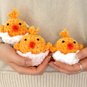 May include: Three crocheted yellow chicks in pink and white egg nests.