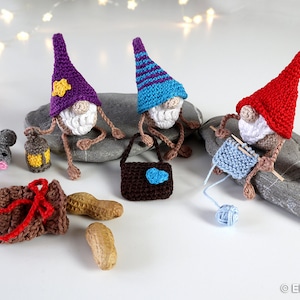 以下が含まれることがあります： 異なる色の帽子をかぶった、編まれた3人のノーム。1人は編み針と毛糸、もう1人は提灯、そしてもう1人は小さな茶色の袋を持っています。また、編まれた2匹のネズミ、茶色の編まれた袋、そして白い表面にピーナッツがあります。