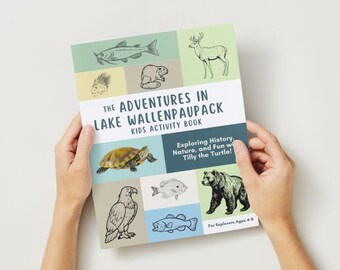 Puede incluir: Un libro de actividades para niños titulado "The Adventures in Lake Wallenpaupack". La portada presenta ilustraciones de peces, un ciervo, una tortuga y un oso. El libro está sostenido por dos manos.