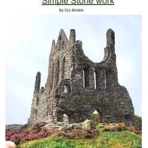 Può includere: Un modello di una rovina in pietra con una finestra alta ad arco e una finestra più piccola sul lato. La rovina è fatta di pietra grigia e si trova su uno sfondo di erba verde.