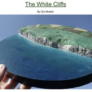 May include: A model of the White Cliffs of Dover, a famous landmark in England. The model is made of white plaster and is painted to look like the real cliffs. The model is set on a blue base that represents the sea.