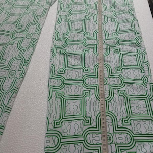 May include: White pants with a green geometric pattern. The pants are measured with a tape measure that shows the length is 110 cm.