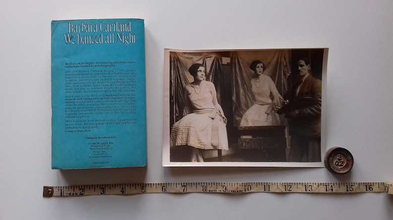 Puede incluir: La contraportada de un libro de bolsillo azul titulado "We Danced All Night" de Barbara Cartland. El libro es una autobiograf&iacute;a y presenta una descripci&oacute;n del libro en la contraportada.