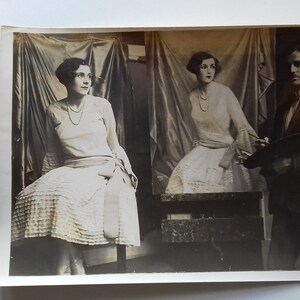 Puede incluir: Una fotograf&iacute;a en blanco y negro de una mujer posando para un retrato. La mujer lleva un vestido blanco y est&aacute; sentada en una silla. Un hombre est&aacute; de pie detr&aacute;s de ella, sosteniendo un pincel y una paleta.