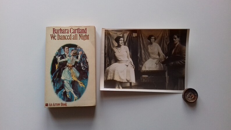 Puede incluir: Un libro de bolsillo vintage titulado "We Danced All Night" de Barbara Cartland. La portada muestra una pareja bailando en un entorno azul y verde.