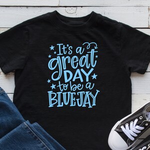 May include: Black t-shirt with blue text that reads "It's a great day to be a Bluejay".