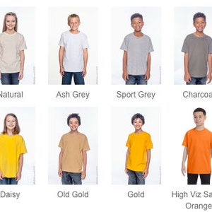 May include: A set of 12 t-shirts in various colors, including white, natural, ash grey, sport grey, charcoal, dark heather, yellow haze, daisy, old gold, gold, high viz safety orange, and orange. The t-shirts are all short-sleeved and have a crew neck.