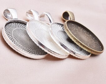 Puede incluir: Cuatro bandejas redondas de plata y bronce para colgantes con un patrón decorativo. Las bandejas están apiladas una encima de la otra.