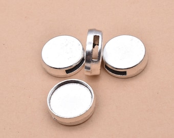 May include: Four silver-toned metal round beads with a small opening on the side. The beads have a smooth, shiny surface.