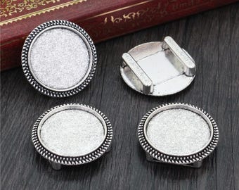 May include: Four silver-toned metal round tray blanks with a raised edge. The trays are perfect for crafting and creating custom jewelry.