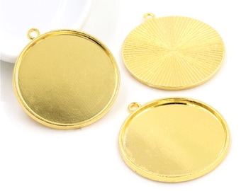 Puede incluir: Tres bandejas redondas para colgantes de metal de color dorado. Las bandejas tienen un acabado liso y brillante y están listas para ser rellenadas con resina u otros materiales de artesanía.