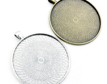 May include: Two round metal pendant trays with a decorative pattern. The tray on the left is silver and the tray on the right is bronze.