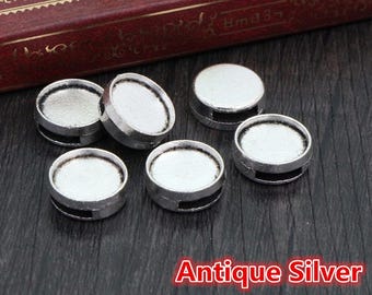 May include: Six antique silver round metal beads with a raised edge. The beads have a smooth, shiny surface. Antique Silver.