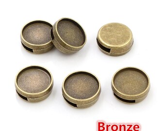 May include: Six bronze-colored metal round bezel settings with a flat surface and a small opening on the side. The bezels are arranged in two rows of three.
