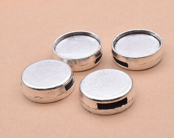 May include: Four silver-toned round metal beads with a small opening on the side. The beads have a smooth, slightly raised surface.