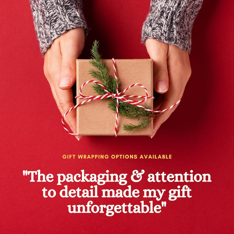 May include: A small, square, brown gift box tied with red and white twine and decorated with a sprig of evergreen. The box is held in two hands against a red background. Text reads: "The packaging & attention to detail made my gift unforgettable."