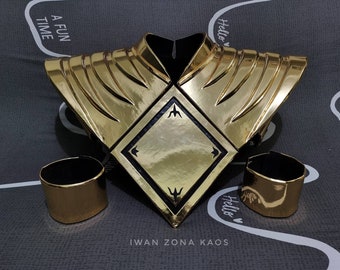 May include: Gold Power Ranger costume accessory set featuring a chest piece with a black diamond and two gold wrist cuffs. The chest piece has a black diamond with a gold trim and a gold design on the outside. The wrist cuffs are solid gold with a black interior.