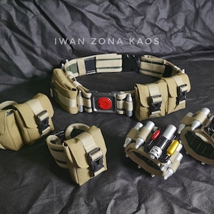 May include: A set of beige tactical gear, including a belt with pouches, two small pouches, and two wrist-mounted pouches with multiple compartments. The belt has a red buckle and the pouches have black buckles. The text "IWAN ZONA KAOS" is visible in the background.