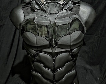 May include: Black and grey Batman costume chest piece with a sculpted bat symbol and textured details.