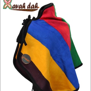 May include: A colorful, striped blanket with a black border. The blanket features diagonal stripes of red, blue, yellow, green, and a dark purple. The blanket has the text "Xavah dah" in the upper left corner.